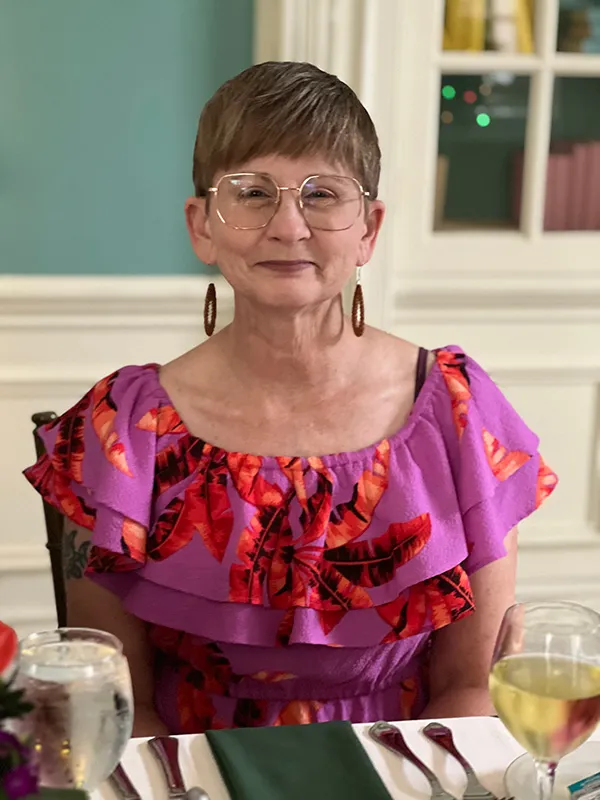 woman smiling while standing in garden